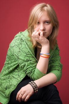 The young girl in green clothes on a red background.