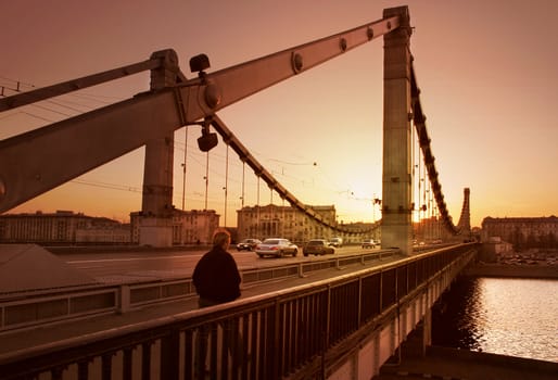 The Solitary man, going on bridge toward. Evening, Moscow, Russia