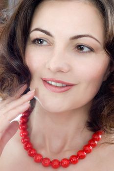 beautiful middle-aged woman wearing red corall beads, isolated on white