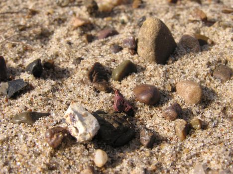 Some little stones on sand close-up