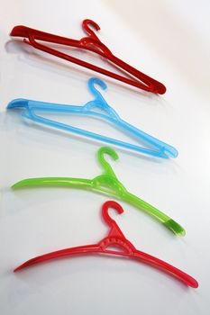 Colored plastic coat hangers on a wall. Bottom view.