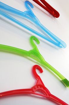 Colored plastic coat hangers on a wall. Bottom view.