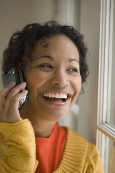 Young beautiful African American woman laughing on cell phone