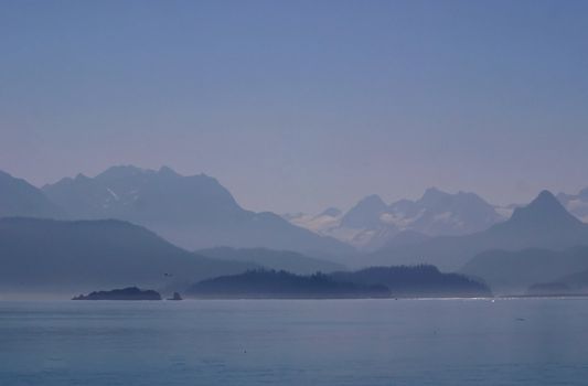 Mountains and glaciers seem shrouded in mystery as day breaks over the misty, chilly waters of Katchemak Bay off the Kenai Penninsula in Alaska