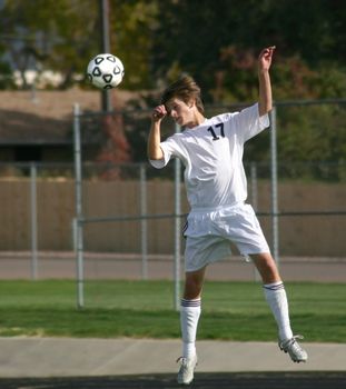 Soccer player hits ball with head.