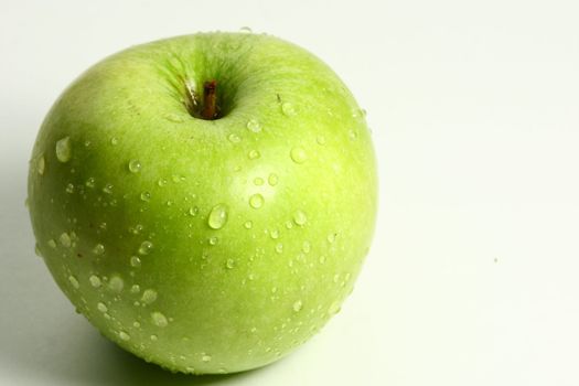 green fresh apple and waterdrops from it