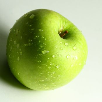 green fresh apple and waterdrops from it