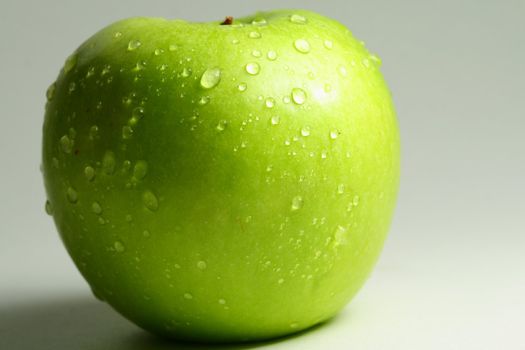 green fresh apple and waterdrops from it