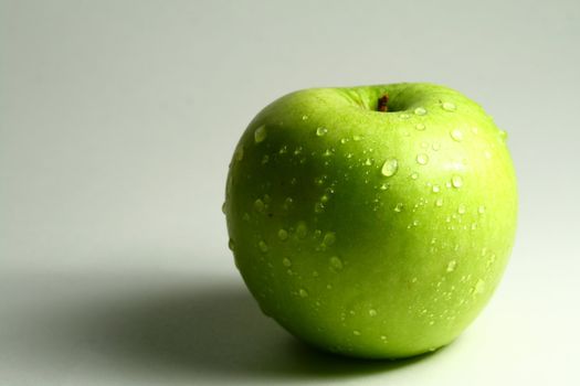 green fresh apple and waterdrops from it