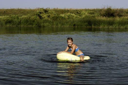 The Girl playing in water on  inflatable  boat.
