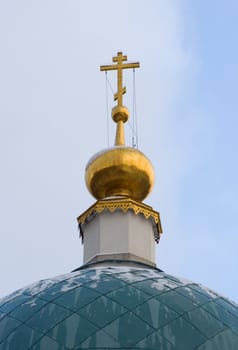Dome with cross of the Russian orthodoxal church against sky on a winter day