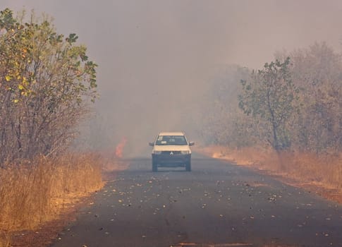 Bush Fire in The Gambia showing flames near vehicle just driven through fire