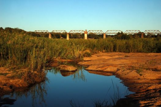 Iron train bridge over the Skukuza River in Africa