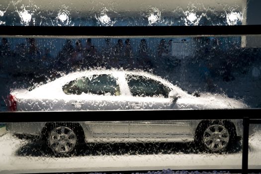 Car behind glass window with water in shopping mall