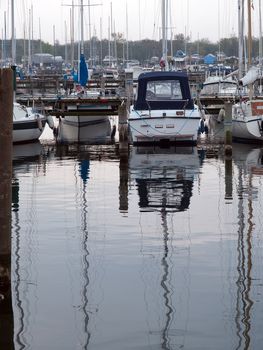 Yachts and sail boats moored to docks in a marina 