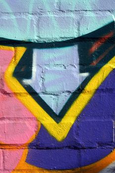 Arrow symbol pointing downwards. Detail of an illegal graffiti sprayed on a bricked wall.