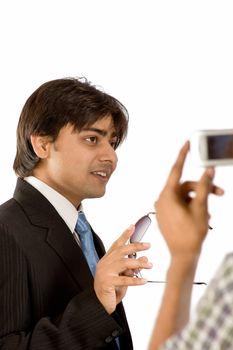 Man with goggles in black suit and tie talking to somebody 