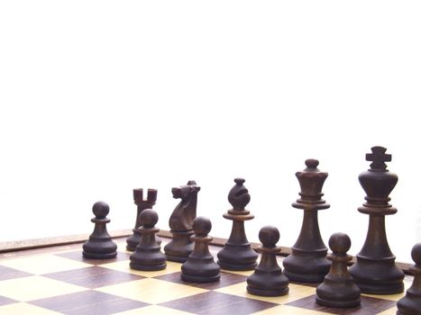 black chessmen on chess board in the beginning of game