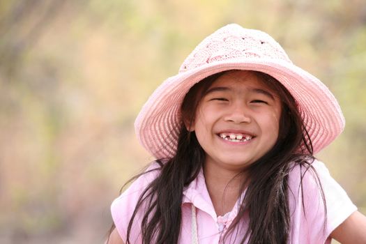 Adorable girl in pink smiling outdoors