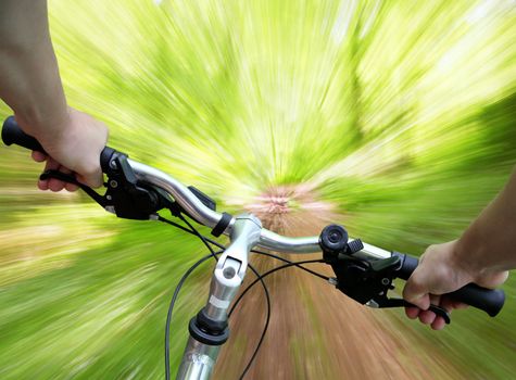 Mountain biking down the trail, descending fast, subjective point of view