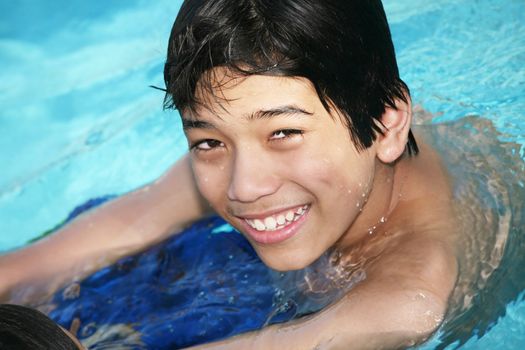 Smiling Young boy swimming in pool