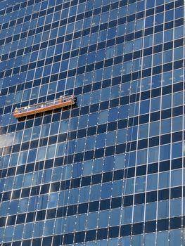 Window washers cleaning the glass on a downtown office building.