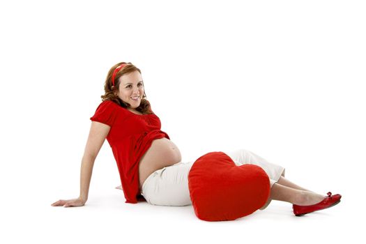 Beautiful pregnant woman enjoying this wonderful moment with a red Heart