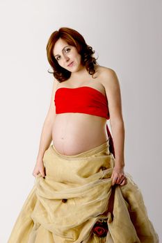 Pregnant woman posing on white with beautiful dress