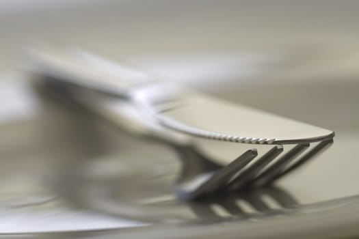 Fork and knife on white background in close-up view. Soft-focus.