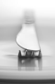 Fork and knife on white background in close-up view. Soft-focus.