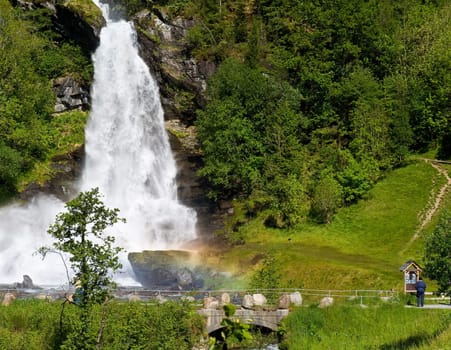 A beautiful waterfall with a rainbow on a sunny summer day