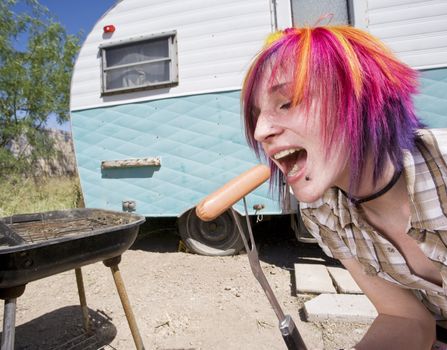 Girl in front of a trailer with a hotdog and a barbecue