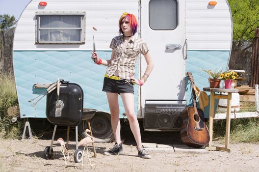 Girl in front of a trailer with a hotdog and a barbecue