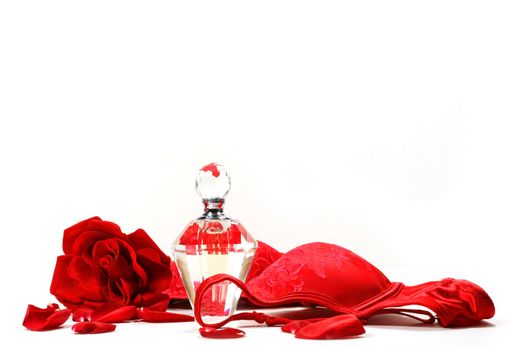 Perfume bottle,  rose and red brassiere on white background