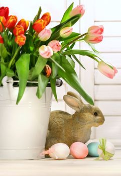 Pot of tulips with rabbit on the counter