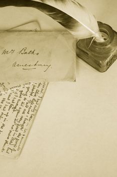 Sepia toned image of an ink pot with feathered quill and hand written letters (recreated by self). Portrait format.