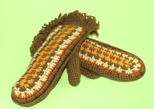 Knitted mittens with pattern on green background