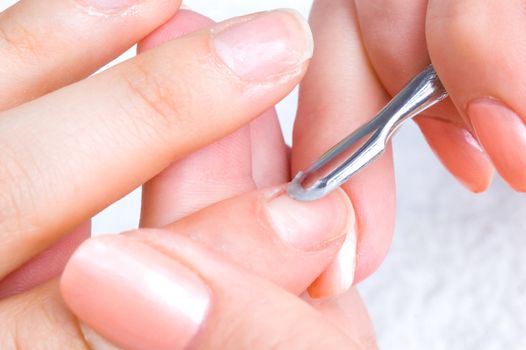 manicure applying - cleaning the cuticles with special istrument