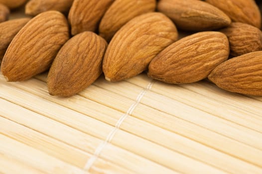 Group of almonds on a bamboo mat, close up.