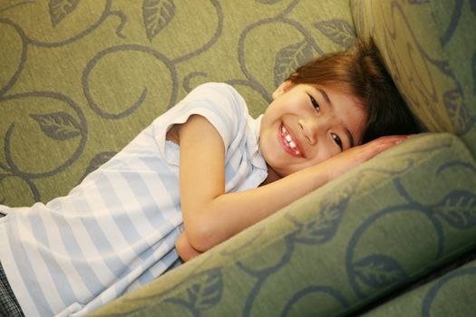 Happy Little girl lying on couch
