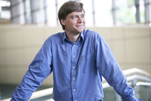 Handsome businessman smiling , relaxed in  large office complex