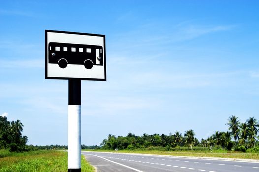 A bus stand signpost on a deserted road.  