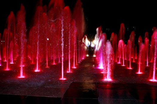 Colorful Fountain with People Silhouettes at night