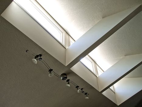 Track lighting on the ceiling near a skylight in a urban home.