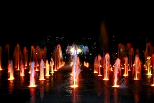 Fountain at night with silhuettes