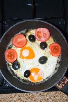 
Eastern fried omelet with tomatoes and olives in a pan
	
Eastern fried omelet with tomatoes and olives in a pan