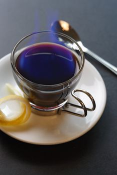 An image of a Carajillo - Spanish drink combining coffee with brandy or rum.  Set aflame to heat the coffee, sugar and liquor. Selective focus - focus is on the rim of the glass.