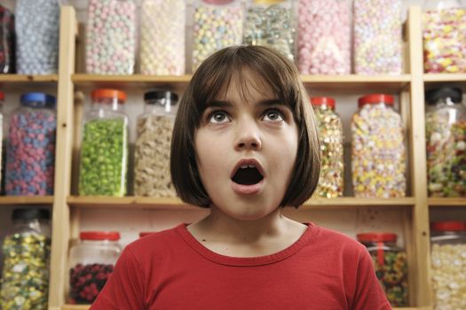 young girl looking in awe at rows of sweets