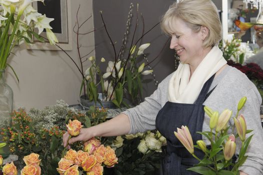 Florist picking flowers from her shop to make a bouquet