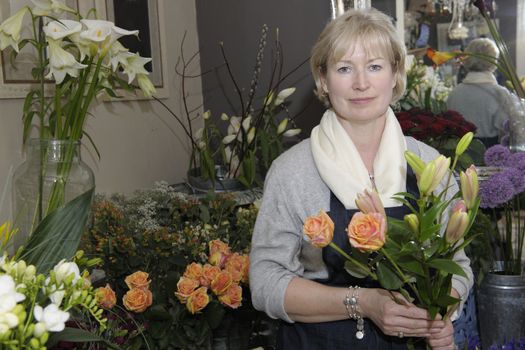 Florist holding a bouquet of flowers in her shop